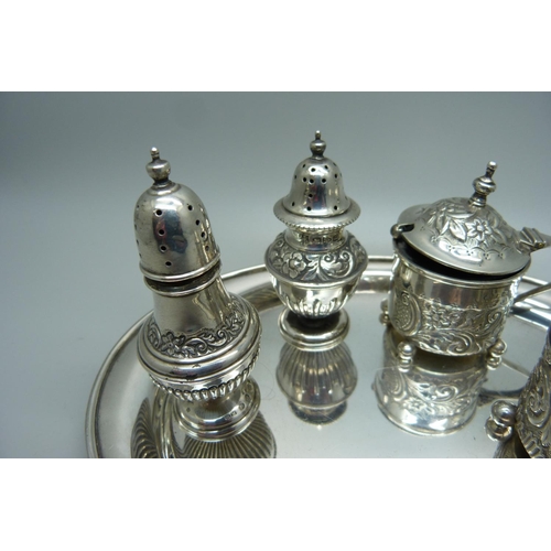 875 - Two Victorian silver rococo style mustards and two Victorian silver peppers with a later oval silver... 