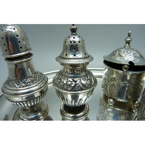 875 - Two Victorian silver rococo style mustards and two Victorian silver peppers with a later oval silver... 