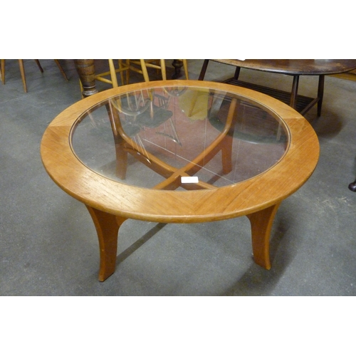 59 - A circular teak and glass topped coffee table