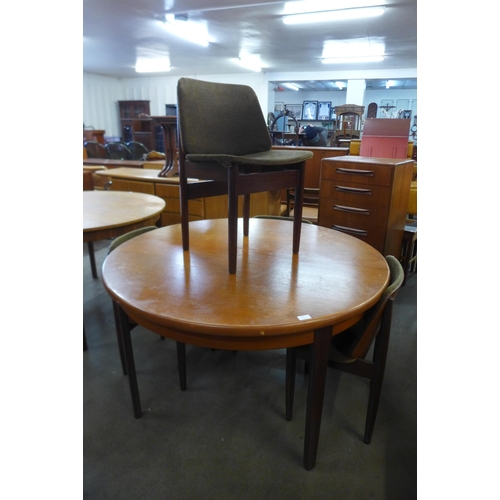 35 - A teak circular extending dining table and four Elliotts of Newbury teak dining chairs