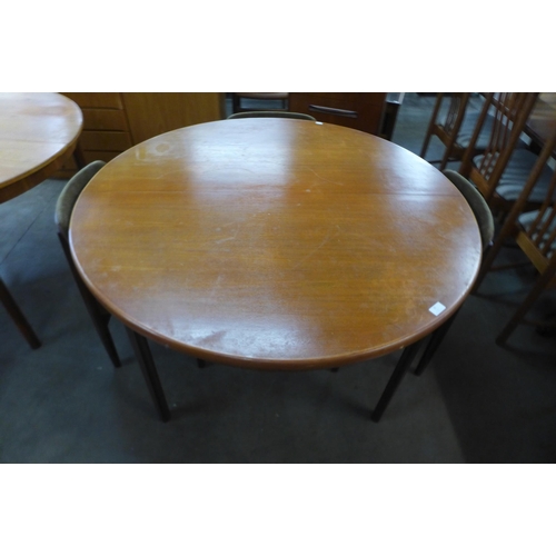 35 - A teak circular extending dining table and four Elliotts of Newbury teak dining chairs