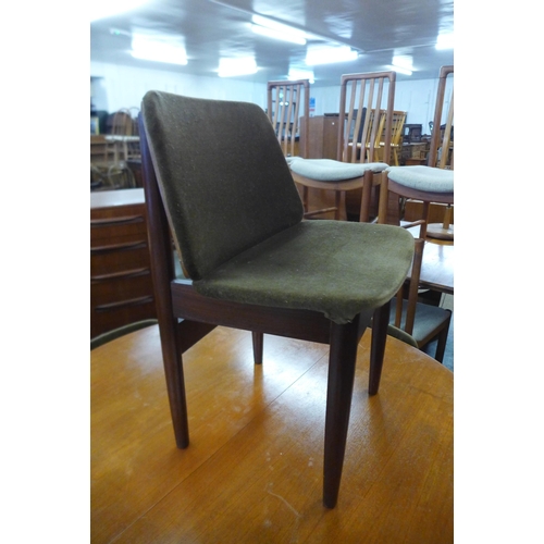 35 - A teak circular extending dining table and four Elliotts of Newbury teak dining chairs