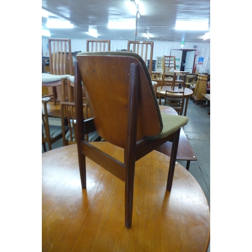 35 - A teak circular extending dining table and four Elliotts of Newbury teak dining chairs