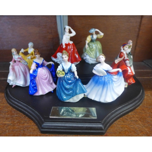 634 - A set of nine Royal Doulton miniature figures of ladies and display stand