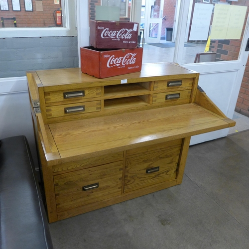 1323 - An oak eight drawer campaign desk