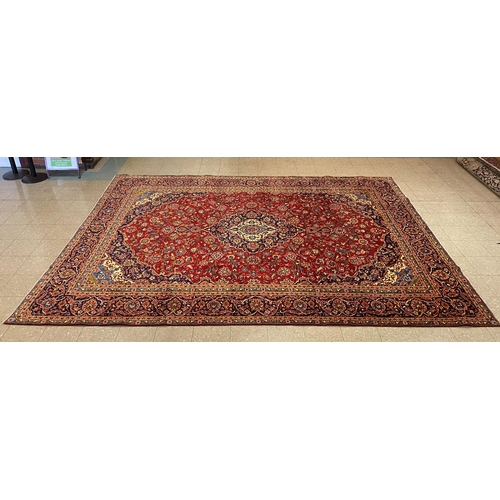 80 - A large Persian red ground Kashan rug, 409 x 294cms