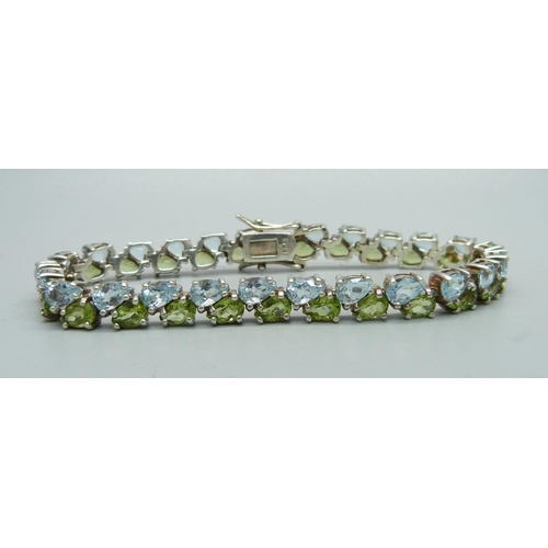 1066 - A silver, topaz and peridot bracelet