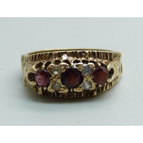 1075 - A 1970's 9ct gold and garnet trilogy ring with bark effect, 3.3g, M