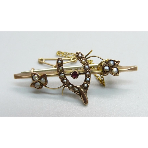 1087 - A 9ct gold and seed pearl wishbone brooch, 2.5g