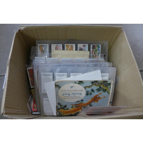 694 - A box of cigarette and trade cards in albums, sleeves and loose