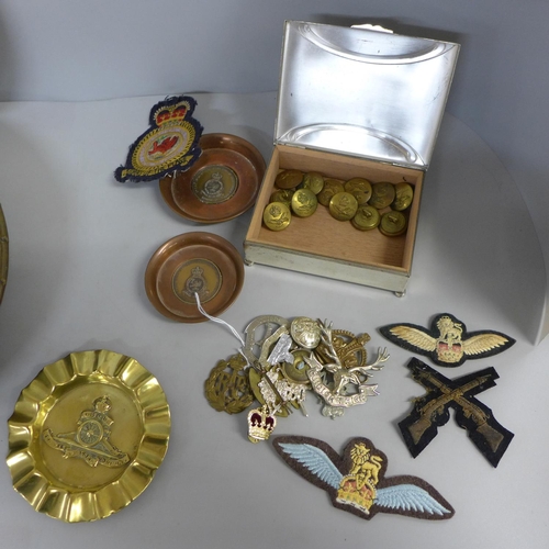 756 - A collection of militaria, cap badges, plates, ash trays, etc.