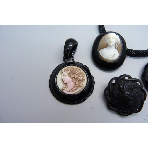 990 - A jet brooch with cameo, two jet pendants, one with cameo and chipped, a jet earring/pendant, a bang... 