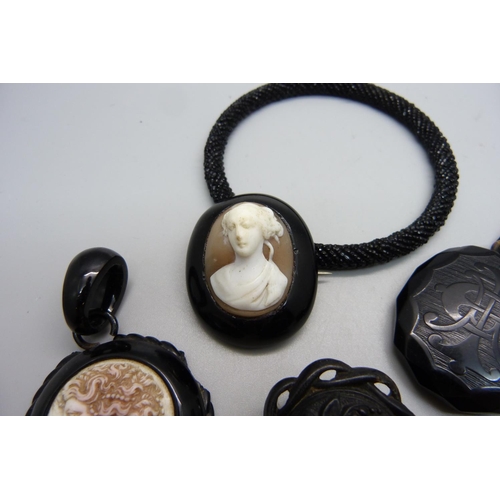 990 - A jet brooch with cameo, two jet pendants, one with cameo and chipped, a jet earring/pendant, a bang... 