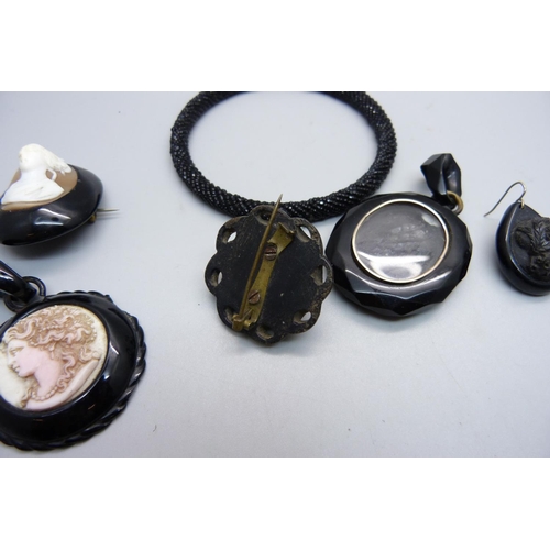 990 - A jet brooch with cameo, two jet pendants, one with cameo and chipped, a jet earring/pendant, a bang... 