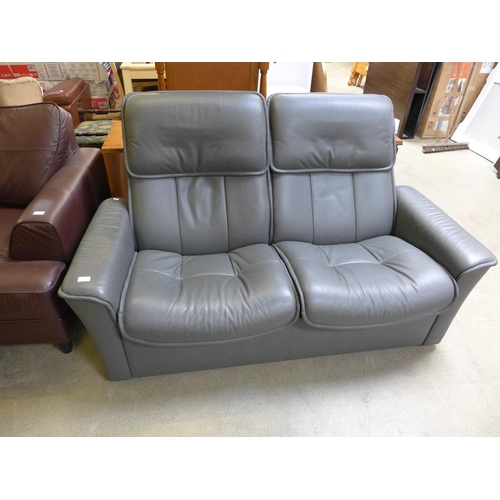 1558 - A grey leather pushback reclining two seater sofa