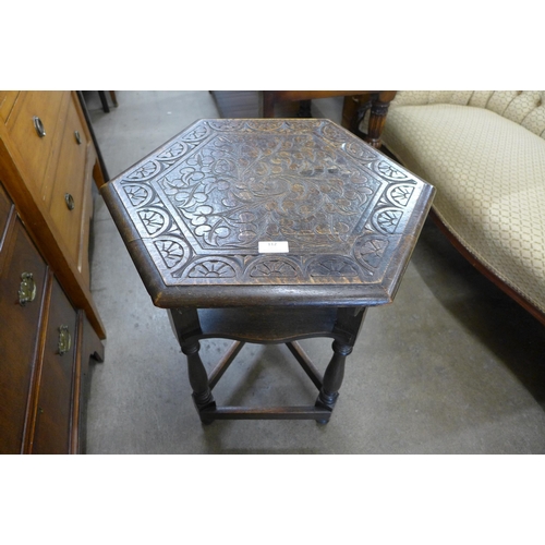 112 - An Arts and Crafts carved oak hexagonal occasional table