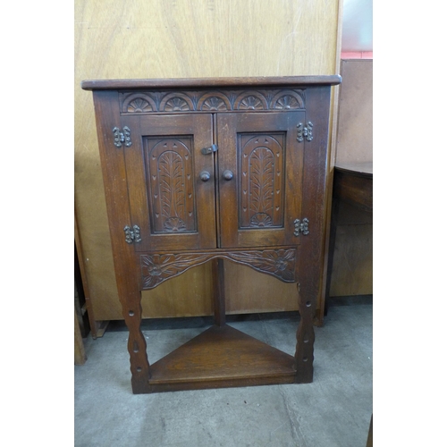 120 - A small carved oak corner cabinet