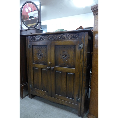 152 - A carved oak two door cupboard