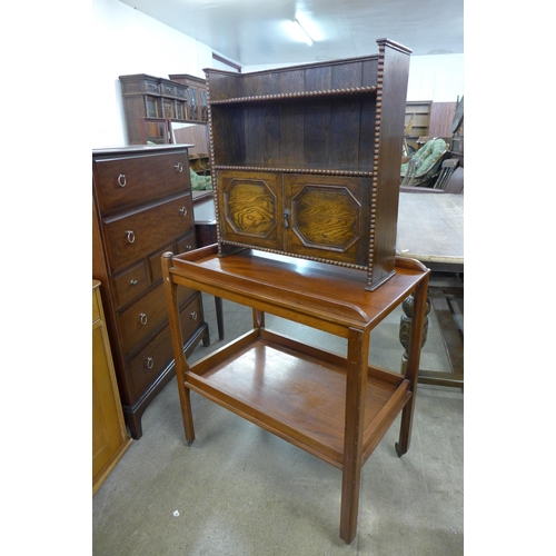 174 - A mahogany two tier trolley and a oak wall hanging cupboard