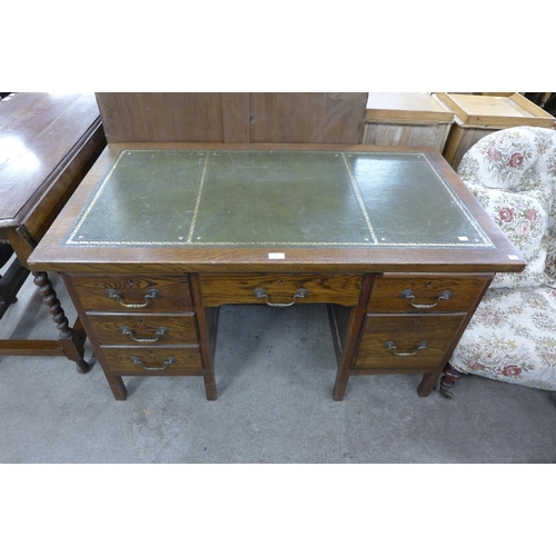 180 - An oak and green leather topped pedestal desk