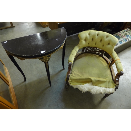 212 - A Victorian walnut tub chair and a French ebonised and parcel gilt demi-lune hall table