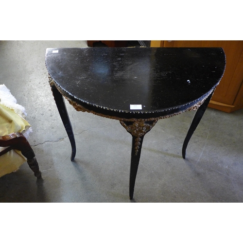 212 - A Victorian walnut tub chair and a French ebonised and parcel gilt demi-lune hall table