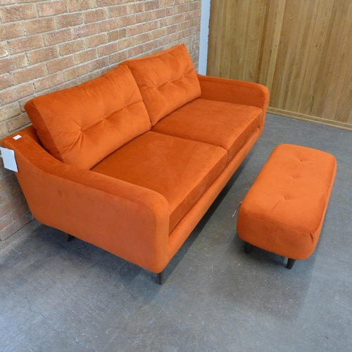 20 - A tangerine velvet buttoned back three seater sofa and footstool (H=90cm x W=187cm x D=90cm)