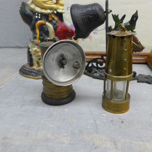 1116 - A cast iron punch doorstop, miniature miner's lamp, wall bracket with bell, three vintage tins inclu... 