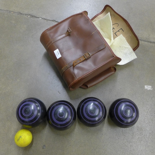 1132 - A set of four lawn bowls and a jack in a leather case