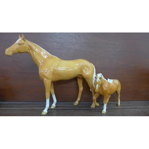 611 - A large Beswick palomino horse and one other smaller, chip to ear on smaller horse