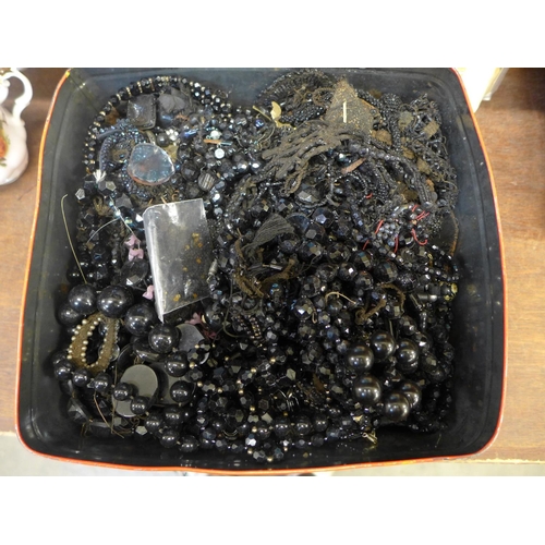 682 - A tin of jet and black bead jewellery