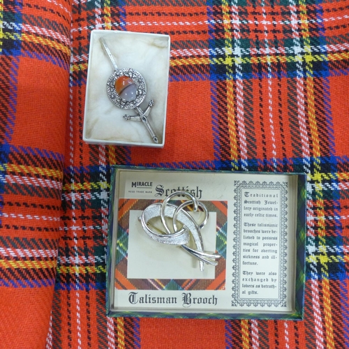 779 - A piece of Tartan cloth and two Scottish brooches