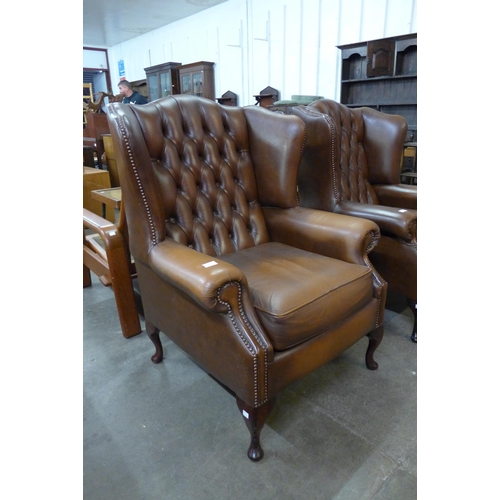 100 - A chestnut brown leather Chesterfield wingback armchair