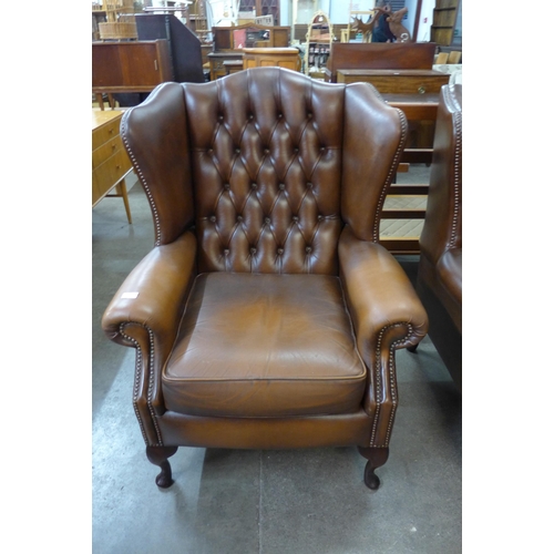 100 - A chestnut brown leather Chesterfield wingback armchair