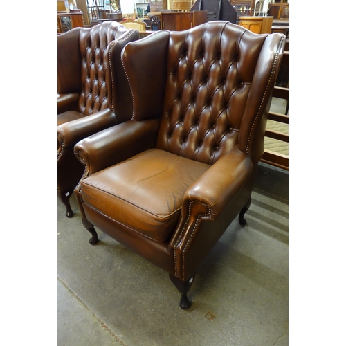 101 - A chestnut brown leather Chesterfield wingback armchair