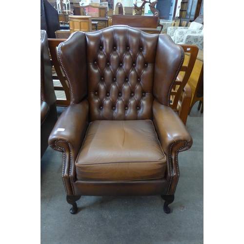 101 - A chestnut brown leather Chesterfield wingback armchair