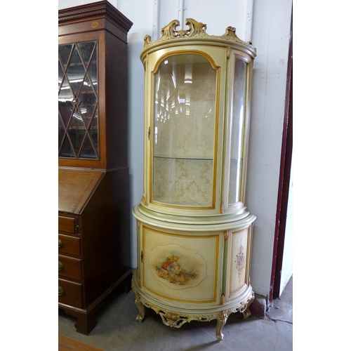 194 - An Italian style cream and parcel gilt demi-lune display cabinet