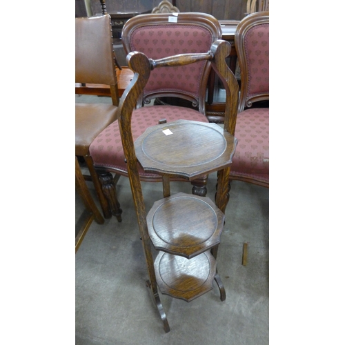 235 - A pair of Victorian mahogany dining chairs and an oak folding cake stand