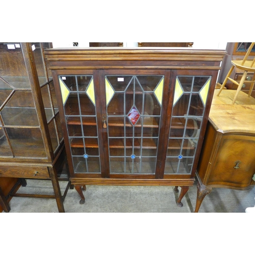 267 - An Art Deco mahogany and stained glass single door bookcase on stand