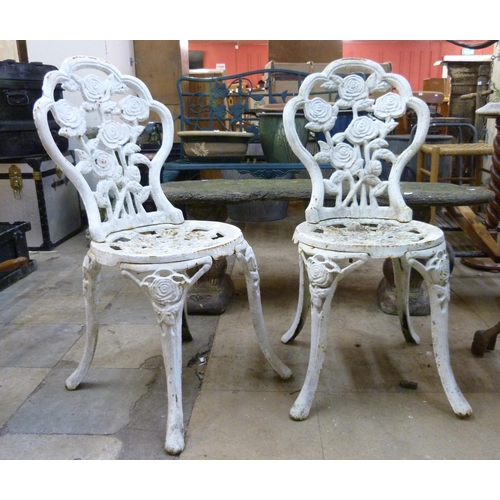 321 - A pair of Victorian style panted cast iron garden chairs