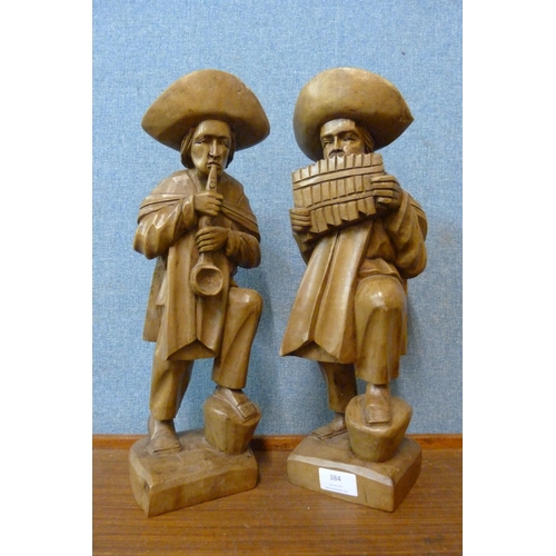 384 - A pair of South American carved wood figures of musicians