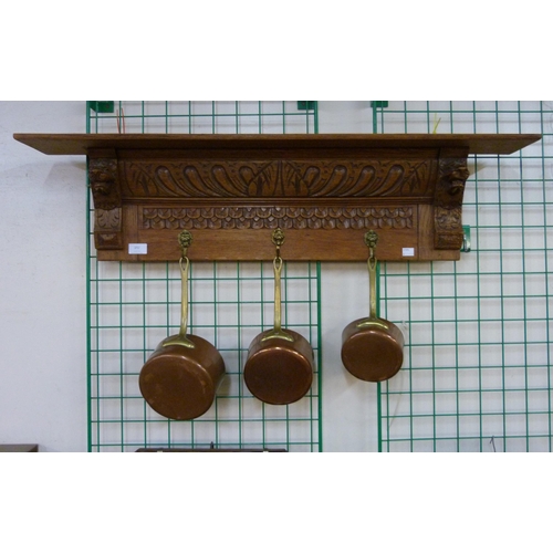 392 - A carved oak pan rack with graduated pans