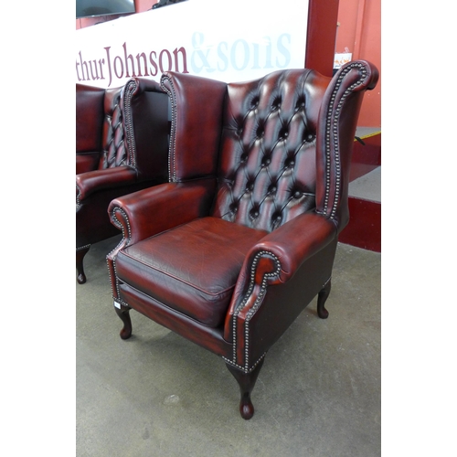 94 - An oxblood red leather Chesterfield wingback armchair