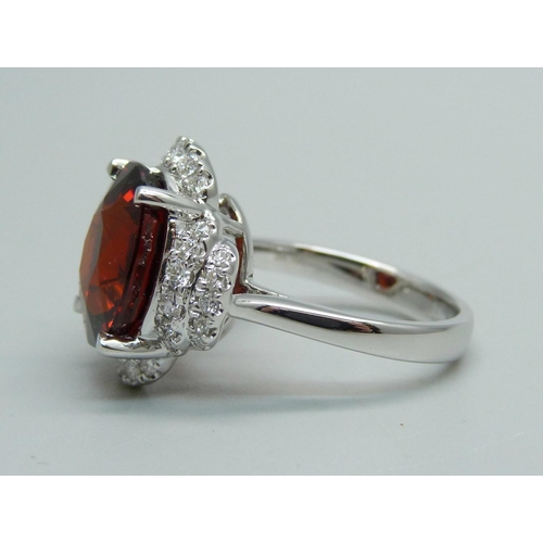 1064 - An 18ct white gold, spessartite garnet and diamond ring, garnet weight 9.03ct, diamond weight 0.47ct... 