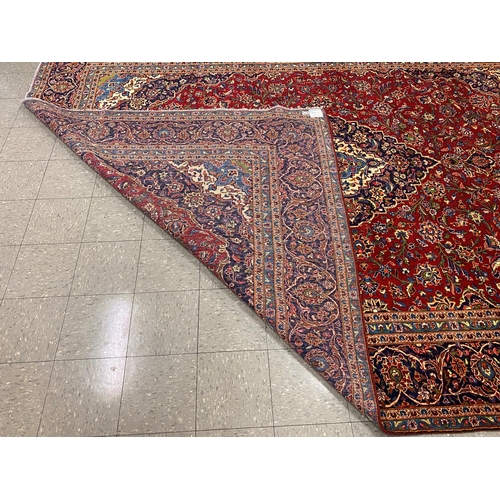 22 - A large Persian red ground Kashan rug, 409 x 294cms