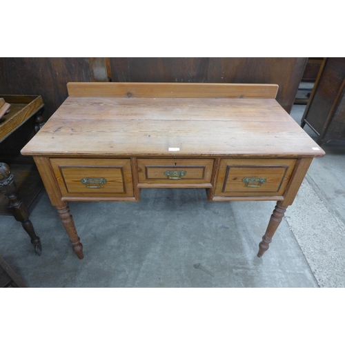 188 - A Victorian pitch pine three drawer writing table