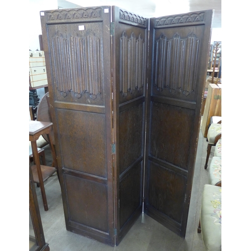 212 - A carved oak linenfold three panel folding dressing screen