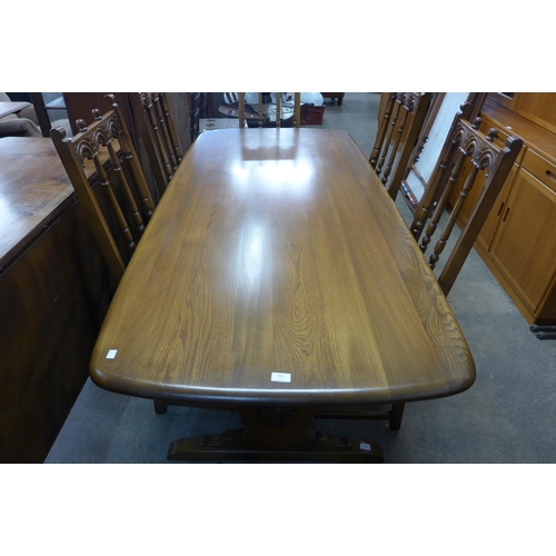 224 - An Ercol Golden Dawn elm eight piece dining suite, comprising; refectory table six chairs and a dres... 