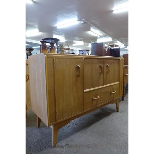 37 - A G-Plan Brandon light oak dining suite, comprising; sideboard, drop-leaf table and four chairs