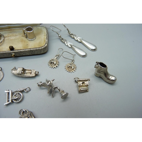 1003 - Silver jewellery comprising thirteen silver charms including one enamelled, three pairs of silver ea... 